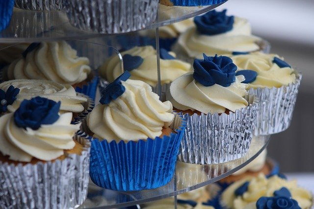 a blue topping on small cakes on a wedding table